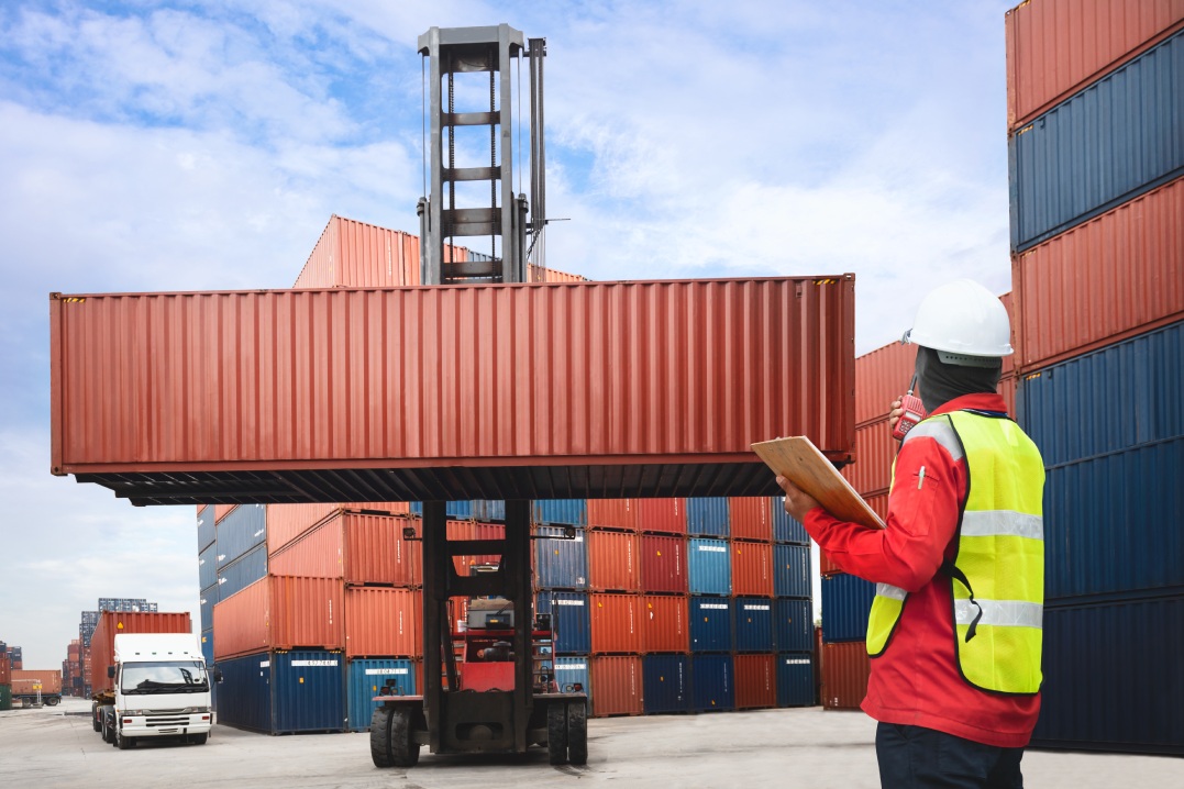 Foreman control loading containers box from cargo freight ship