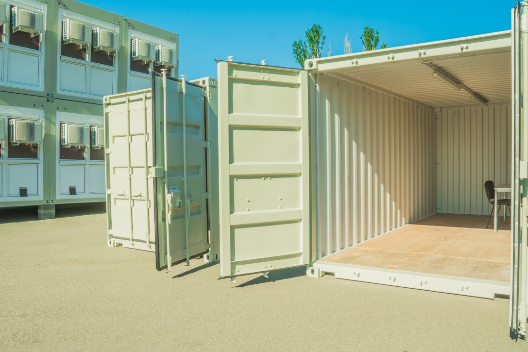 Container on a construction site, exterior. Mobile building. Cargo container apartment. Prefabricated mobile cargo containers with a window and door used for housing, home container, rooms.