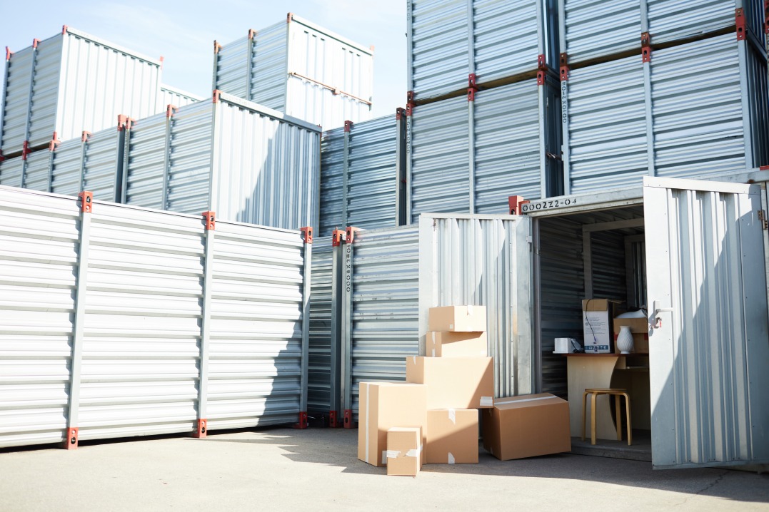 Open storage container with supplies for work and some packed boxes among other ones