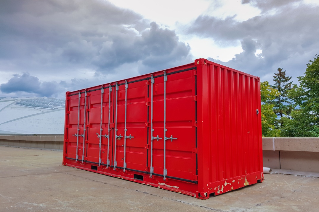 Red container with a dramatic sky in background