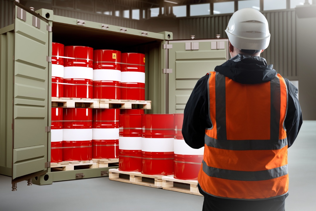 Logistics of chemical products. Man near container with barrels. Sea container with chemical products. Man is logistician in industrial building. Process of loading chemical substances into barrels